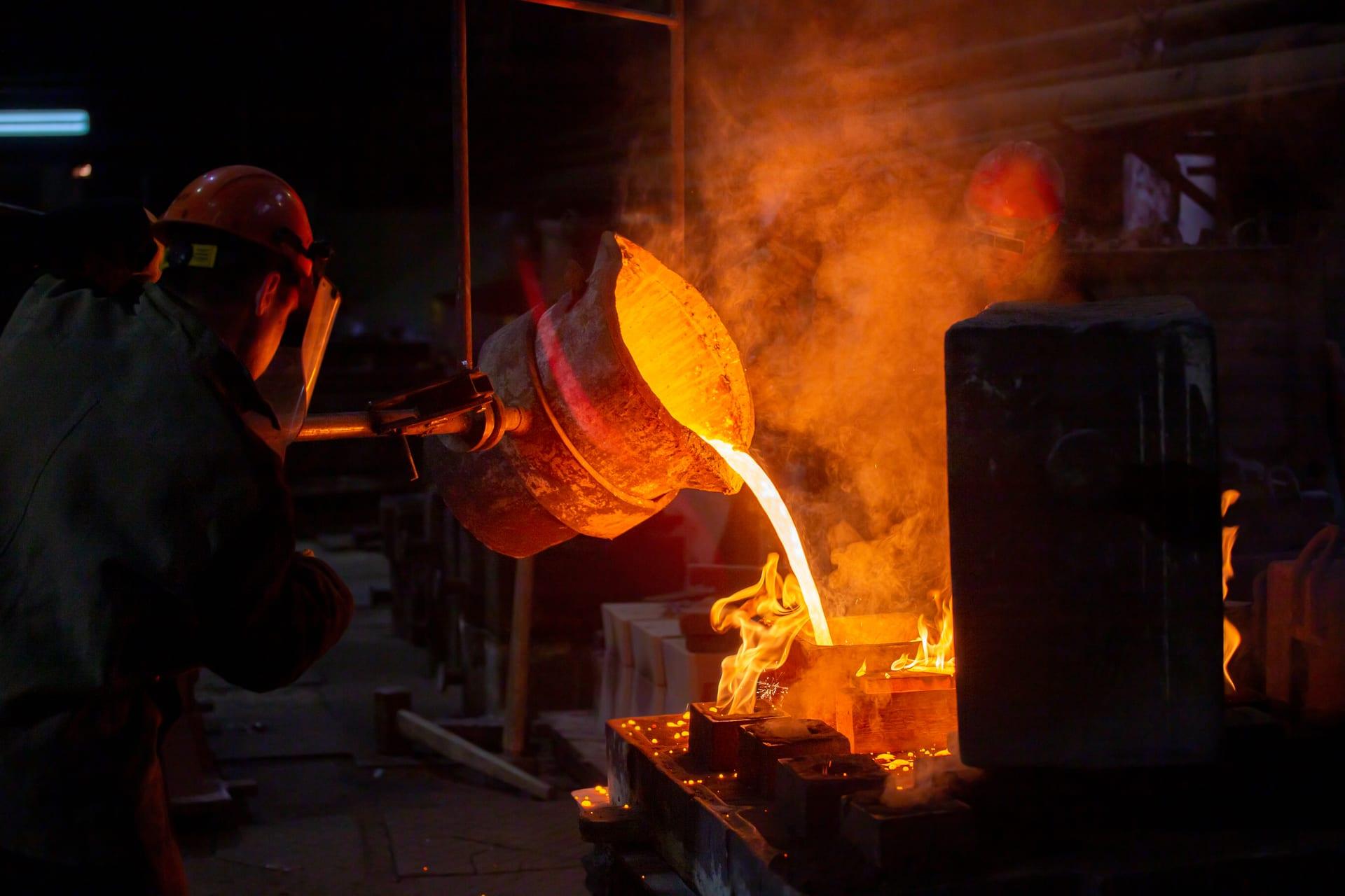 Foundry workers pouring molten metal into a casting mould