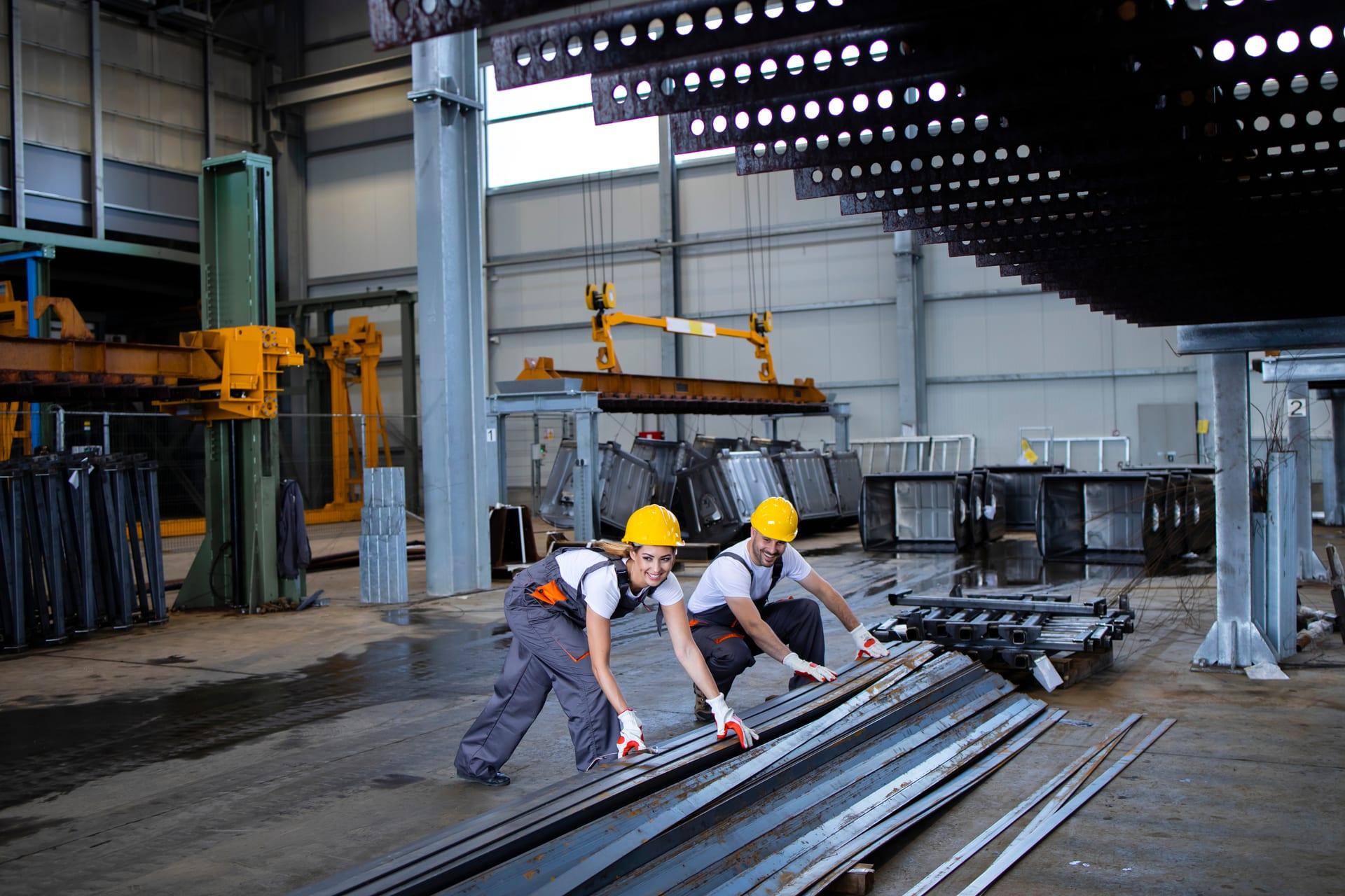 Mill operators guiding steel bar stock on the production floor